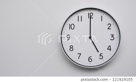 Minimalist Analog Wall Clock with White Face and Simple Black Hands Showing 17.00/05.00 - Ideal for Time Management and Modern Decor Concepts Minimalist Analog Wall Clock with White Face and Simple Black Hands Showing 17.00/05.00 - Ideal for Time Management and Modern Decor Concepts 121929105