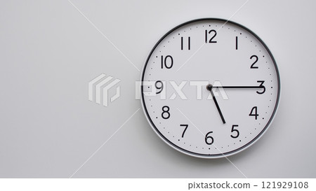 Minimalist Analog Wall Clock with White Face and Simple Black Hands Showing 17.15/05.15 - Ideal for Time Management and Modern Decor Concepts Minimalist Analog Wall Clock with White Face and Simple Black Hands Showing 17.15/05.15 - Ideal for Time Management and Modern Decor Concepts 121929108