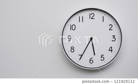 Minimalist Analog Wall Clock with White Face and Simple Black Hands Showing 17.35/05.35 - Ideal for Time Management and Modern Decor Concepts 121929112