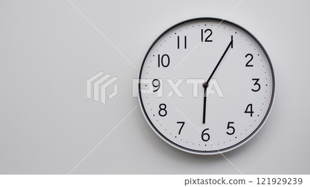 Minimalist Analog Wall Clock with White Face and Simple Black Hands Showing 18.05/06.05 - Ideal for Time Management and Modern Decor Concepts Minimalist Analog Wall Clock with White Face and Simple Black Hands Showing 18.05/06.05 - Ideal for Time Management and Modern Decor Concepts 121929239
