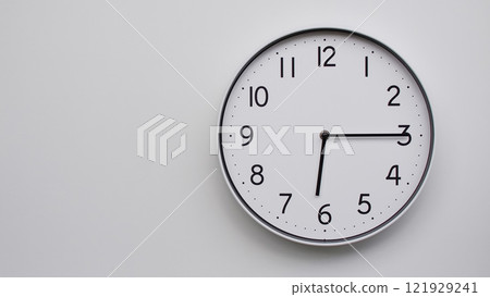 Minimalist Analog Wall Clock with White Face and Simple Black Hands Showing 18.15/06.15 - Ideal for Time Management and Modern Decor Concepts 121929241