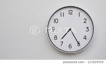 Minimalist Analog Wall Clock with White Face and Simple Black Hands Showing 19.25/07.25 - Ideal for Time Management and Modern Decor Concepts 121929350