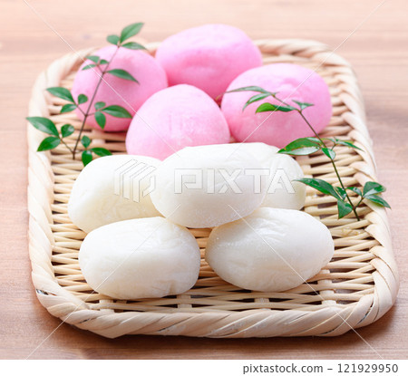 Red and white round rice cakes on a basket 121929950