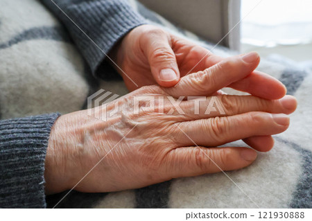 Senior woman's hands touching her knuckles 121930888