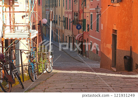 House and street in Liguria. Construction scaffolding and colouring of building facade. City buildings on sunny day. Travelling, sightseeing and holidays in Italy 121931249