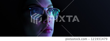 Close-up of focused woman wearing glasses reflecting financial and analytical charts, representing stock market, trading data Close-up of focused woman wearing glasses reflecting financial and analytical charts, representing stock market, trading data 121931479