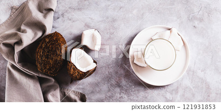 Glass of organic coconut milk and coconut pulp on table top view web banner Glass of organic coconut milk and coconut pulp on table top view web banner 121931853