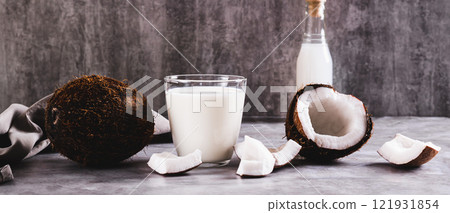 Fresh coconut milk in a glass and coconut pieces on a plate on the table web banner Fresh coconut milk in a glass and coconut pieces on a plate on the table web banner 121931854