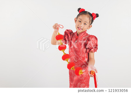 Chinese New Year. Happy Asian Chinese little kid girl smile wearing red cheongsam qipao holding silk lanterns on hand, Portrait children in traditional dress Chinese New Year. Happy Asian Chinese little kid girl smile wearing red cheongsam qipao holding silk lanterns on hand, Portrait children in traditional dress 121933056