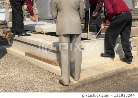 Porters lower the coffin into the grave 121933244