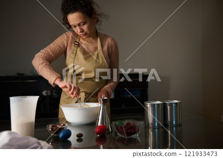 Woman preparing a dessert in a home kitchen during the holiday season Woman preparing a dessert in a home kitchen during the holiday season 121933473