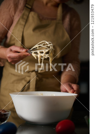 Person Preparing Cake Batter in the Kitchen During Holiday Baking Person Preparing Cake Batter in the Kitchen During Holiday Baking 121933479