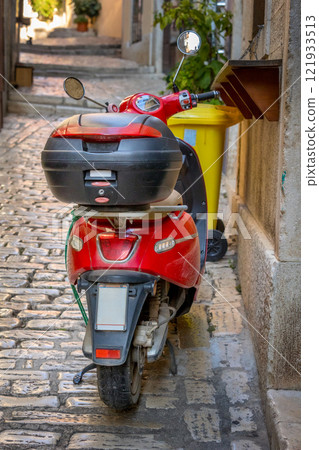 Scooter parked on old street close-up 121933513