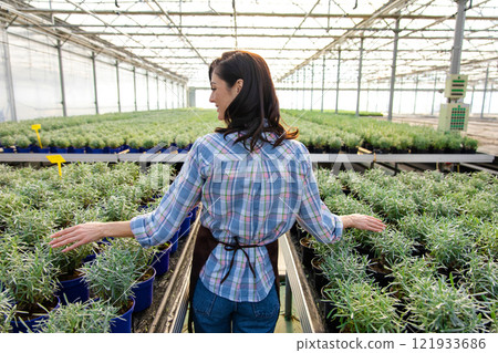 Smiling pretty female glasshouse worker at her working place 121933686