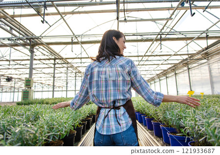 Smiling pretty female glasshouse worker at her working place Smiling pretty female glasshouse worker at her working place 121933687