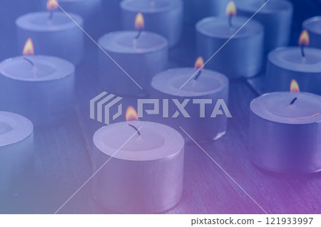 Tea light candles on a dark background, many lights in the dark 121933997