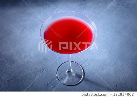 Cosmopolitan cocktail with vodka and cranberry juice in an elegant glass 121934008
