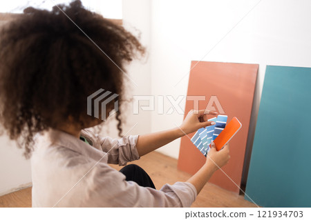 Attractive African woman in casual clothes holds palette of shades of colors 121934703