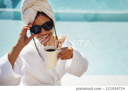 Young pretty woman in a white bathrobe holds a cup of coffee. Young pretty woman in a white bathrobe holds a cup of coffee. 121934724