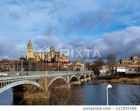 Salamanca. View of Salamanca and the Enrique Estevan bridge from the dock viewing point over the Tormes River. Traditional stone buildings. Salamanca Cathedral. SALAMANCA, SPAIN. 13 JANUARY 2025. 121935566