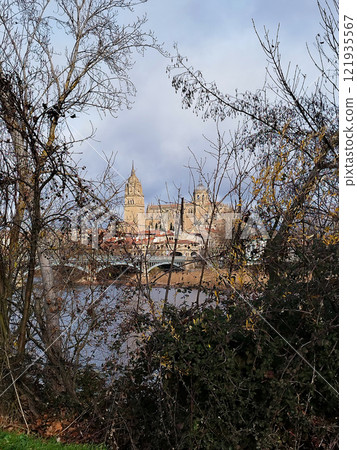 Salamanca. View of Salamanca and the Enrique Estevan bridge from the dock viewing point over the Tormes River. Traditional stone buildings. Salamanca Cathedral. SALAMANCA, SPAIN. 13 JANUARY 2025. Salamanca. View of Salamanca and the Enrique Estevan bridge from the dock viewing point over the Tormes River. Traditional stone buildings. Salamanca Cathedral. SALAMANCA, SPAIN. 13 JANUARY 2025. 121935567