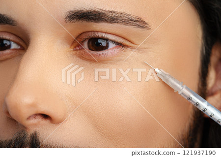 Man receiving facial treatment with a syringe for enhancing appearance 121937190