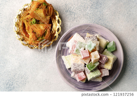 Sweets served on elegant plates display traditional desserts at a festive gathering Sweets served on elegant plates display traditional desserts at a festive gathering 121937256