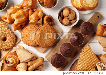 Delicious assortment of baked goods on a wooden table highlighting sweet treats and snacks Delicious assortment of baked goods on a wooden table highlighting sweet treats and snacks 121937331