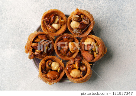Traditional sweet delicacy made from rolled pastry and a variety of nuts served on a plate 121937347