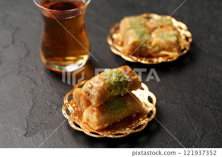 Delicious pastries and tea served on decorative plates in a cozy setting during an afternoon gathering 121937352