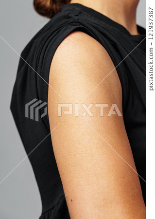 person's arm in a black top with rolled sleeves person's arm in a black top with rolled sleeves 121937387