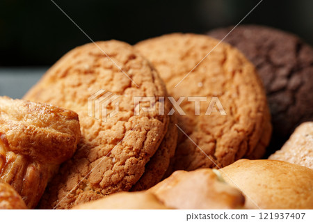 Assorted cookies displayed on a plate with various textures and colors in a warm setting Assorted cookies displayed on a plate with various textures and colors in a warm setting 121937407