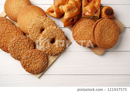 Assorted cookies displayed on wooden board in a cozy setting ready for a delightful snack or dessert time Assorted cookies displayed on wooden board in a cozy setting ready for a delightful snack or dessert time 121937575