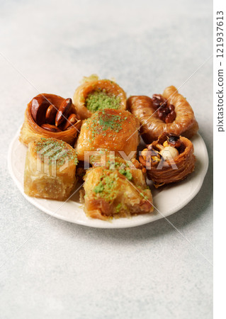 Assorted traditional sweets on a white plate showcasing rich textures and flavors Assorted traditional sweets on a white plate showcasing rich textures and flavors 121937613