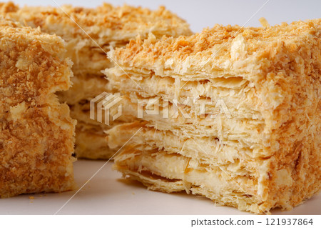 Delicate layers of puff pastry filled with cream displayed on a simple white background Delicate layers of puff pastry filled with cream displayed on a simple white background 121937864