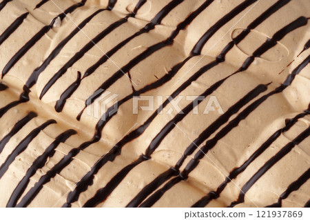 Delicious dessert featuring textured layers of creamy filling drizzled with dark chocolate 121937869