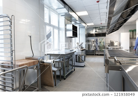 Modern commercial kitchen interior featuring stainless steel appliances and ample workspace for food preparation Modern commercial kitchen interior featuring stainless steel appliances and ample workspace for food preparation 121938049