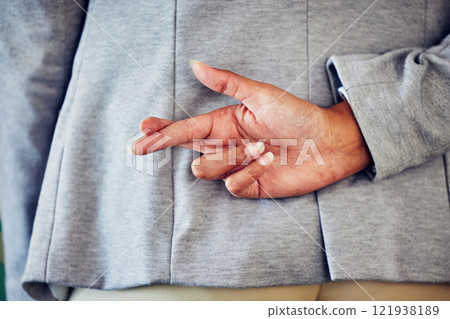 Hand gesture, sign or icon of a liar not telling the truth and being dishonest. Female waiting for good news and holding a sign. Woman crossing fingers for good luck, hope or a lie, behind her back. 121938189
