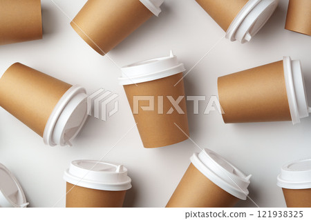 A collection of disposable coffee cups arranged artfully on a white surface 121938325