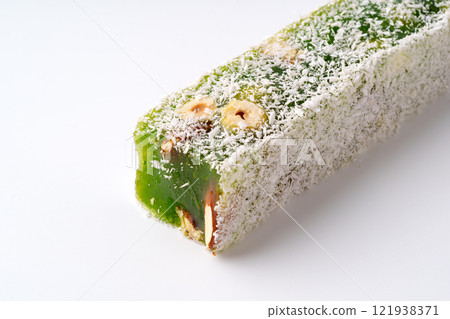 Sweet dessert made from green pistachio with shredded coconut on white background Sweet dessert made from green pistachio with shredded coconut on white background 121938371