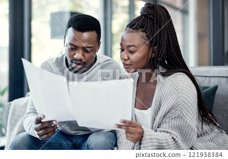 Married couple planning their finance and budget bills or papers together at home. Serious husband and young wife looking at household financial report information and insurance money plan 121938384