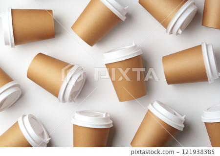 A collection of disposable coffee cups arranged artfully on a white surface 121938385