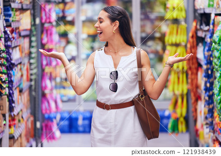 Shopping, store and retail with a young woman customer at a supermarket or shop with products in the background. Money, buying and spending by a female consumer looking happy with options and variety Shopping, store and retail with a young woman customer at a supermarket or shop with products in the background. Money, buying and spending by a female consumer looking happy with options and variety 121938439