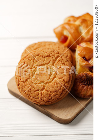 Delicious cookies and pastries arranged on a wooden board Delicious cookies and pastries arranged on a wooden board 121938607