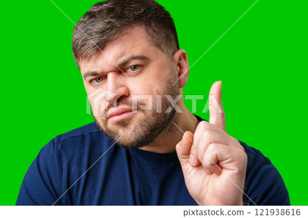 A man thoughtfully ponders on a bright green background 121938616