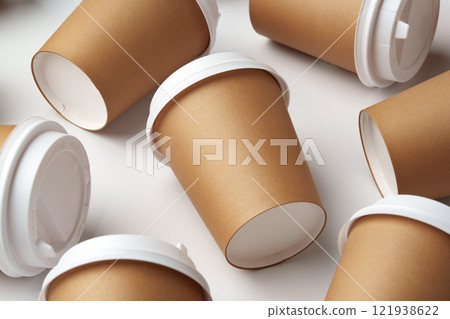 A collection of disposable coffee cups arranged artfully on a white surface 121938622