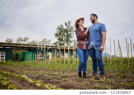 Farmer couple happy about growing vegetable crops or plants in their organic or sustainable farm or garden. Affectionate nature activists enjoying the outdoors and having fun together Farmer couple happy about growing vegetable crops or plants in their organic or sustainable farm or garden. Affectionate nature activists enjoying the outdoors and having fun together 121938667