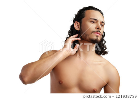 Young man with curly hair thoughtfully posing against a plain background 121938759