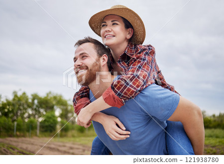 Playful, agriculture farmer couple having fun on a farm, countryside or nature environment enjoying rustic, sustainable living lifestyle. Happy, caring and in love husband giving wife piggyback ride 121938780