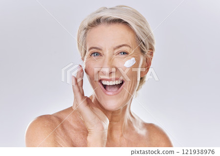 Beauty, skincare and wellness with a senior woman applying lotion, sunscreen or serum to her face in studio on a grey background. Health, skin care and motivation with a beautiful and healthy model Beauty, skincare and wellness with a senior woman applying lotion, sunscreen or serum to her face in studio on a grey background. Health, skin care and motivation with a beautiful and healthy model 121938976